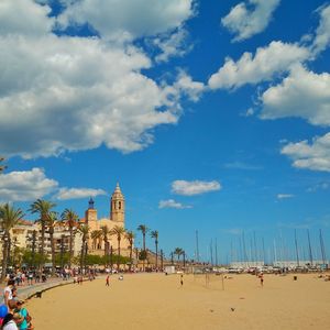 People at beach against blue sky