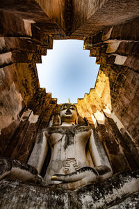 Low angle view of buddha statue against skylight