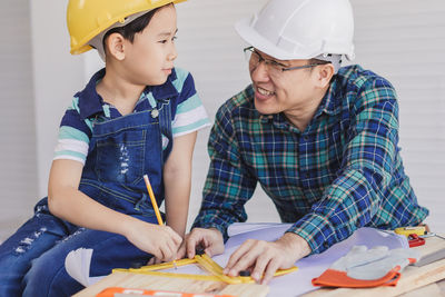 Engineer assisting son in making drawing