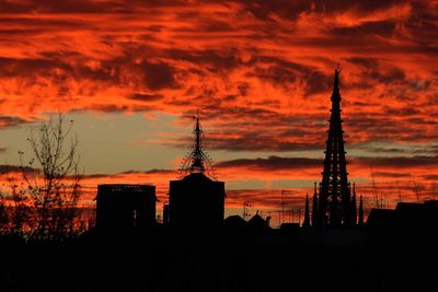 Silhouette of building against cloudy sky at sunset