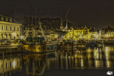 Reflection of buildings in lake at night