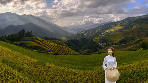 Rear view of man on field against mountains