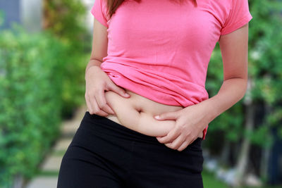 Midsection of woman standing against blurred background