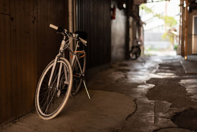 Bicycle standing by the wall of building