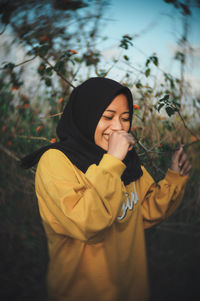 Portrait of smiling young woman standing outdoors