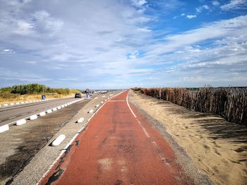 Empty road along landscape against sky