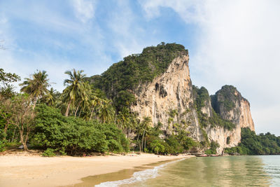 Rock formations on beach against sky