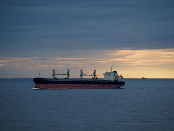 Nautical vessel on sea against sky during sunset