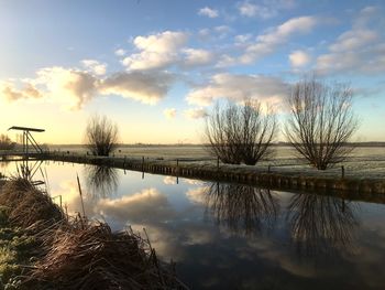 Scenic view of lake against sky at sunset