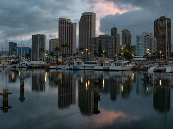 Honolulu skyline reflected in the marina harbor at sunrise