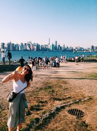 People walking in city against clear sky