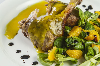 Duck legs with orange sauce and lamb's lettuce salad with oranges and vinegar.
