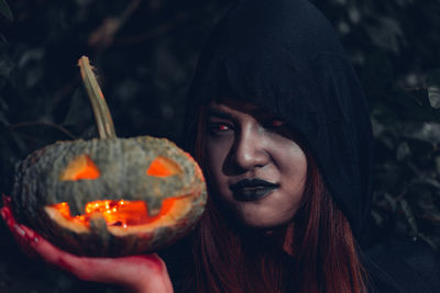 Close-up portrait of young woman holding halloween