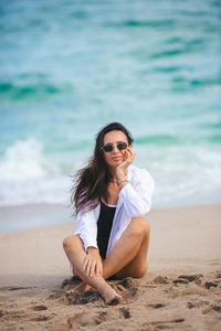 Young woman sitting on beach