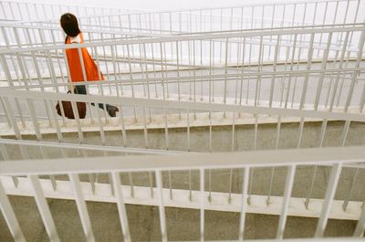Side view of woman walking on bridge by railing