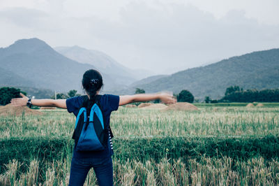 Full length of man with arms outstretched against mountain