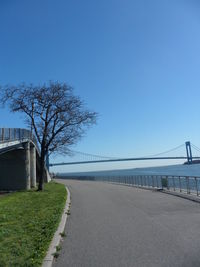 Empty road against clear blue sky