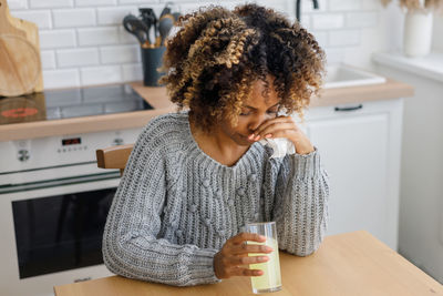 Side view of young woman using mobile phone at home