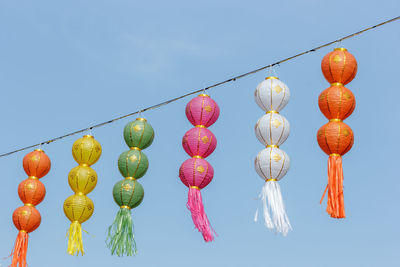 Low angle view of lanterns hanging against clear sky