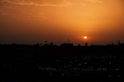 Silhouette buildings against sky during sunset