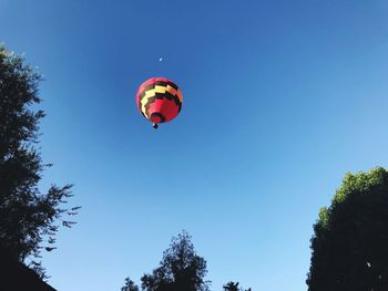 Low angle view of hot air balloon against clear blue sky