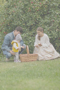 Rear view of father and daughter in basket on land