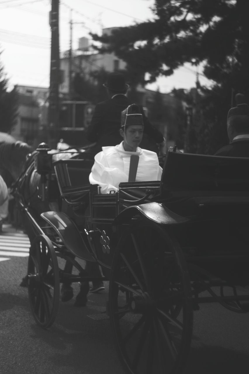 transportation, one person, real people, land vehicle, street, outdoors, mode of transport, tree, road, sitting, full length, day, wheelchair, men, lifestyles, young adult, people