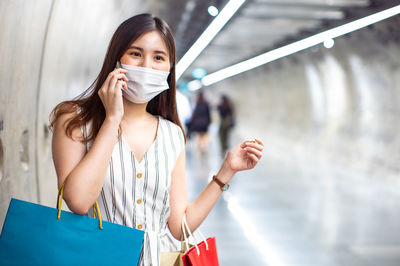 Portrait of beautiful woman holding a while standing against blurred background