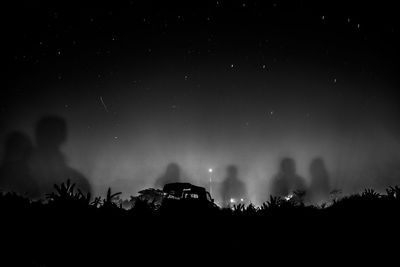 Silhouette people against star field at night