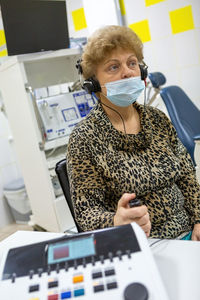 Audiologist checks the hearing of an older woman