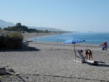 Scenic view of beach against clear blue sky