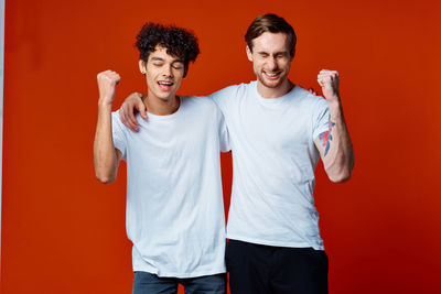 Portrait of smiling young man against red background