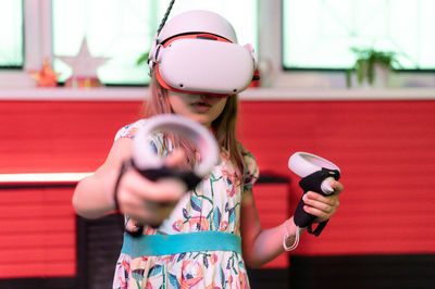 Vr game virtual reality. kid girl gamer playing on futuristic simulation video game in 3d glasses