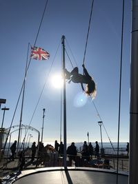 People at amusement park against sky