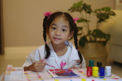 Portrait of cute girl sitting at table