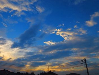 Low angle view of silhouette cables against sky during sunset