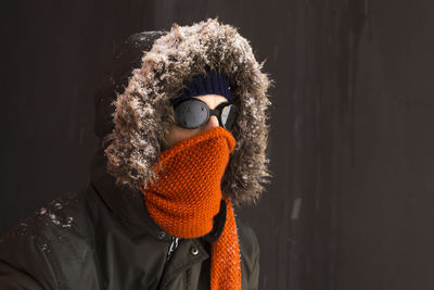 Portrait of person wearing mask against black background