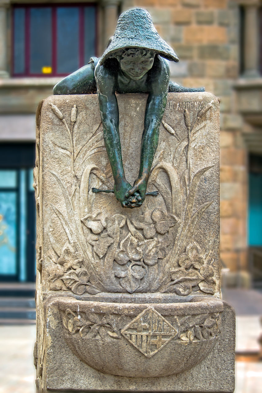 CLOSE-UP OF STATUE AGAINST BUILDING