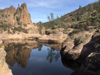 Rock formations by mountains against sky