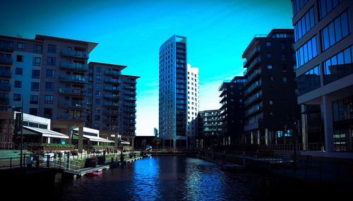 Buildings in city against blue sky