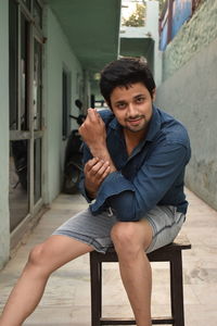 Portrait of young man sitting on seat