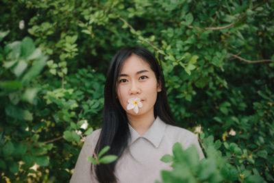 Portrait of young woman eating plant