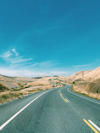 Empty road along countryside landscape