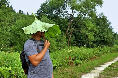 Man standing on field against trees