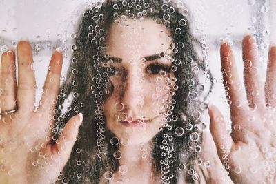 Portrait of teenage girl seen through window