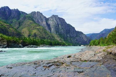 Scenic view of sea and mountains against sky