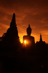 Silhouette statue against sky at sunset