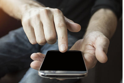 Midsection of man using mobile phone