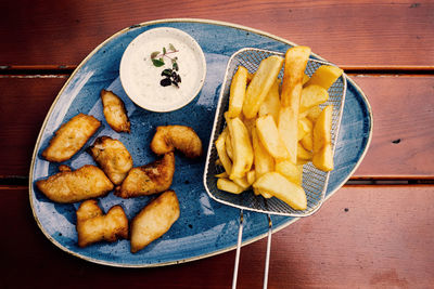 High angle view of fish and chips in plate on table