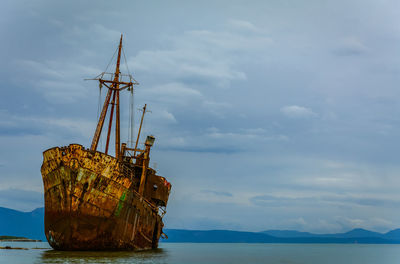 Abandoned ship in sea against sky